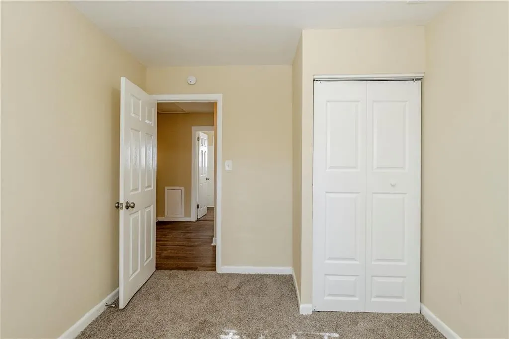 Unfurnished bedroom featuring light colored carpet and a closet