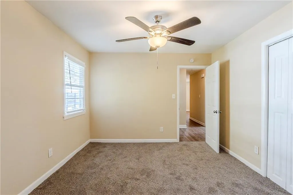 Carpeted spare room featuring ceiling fan