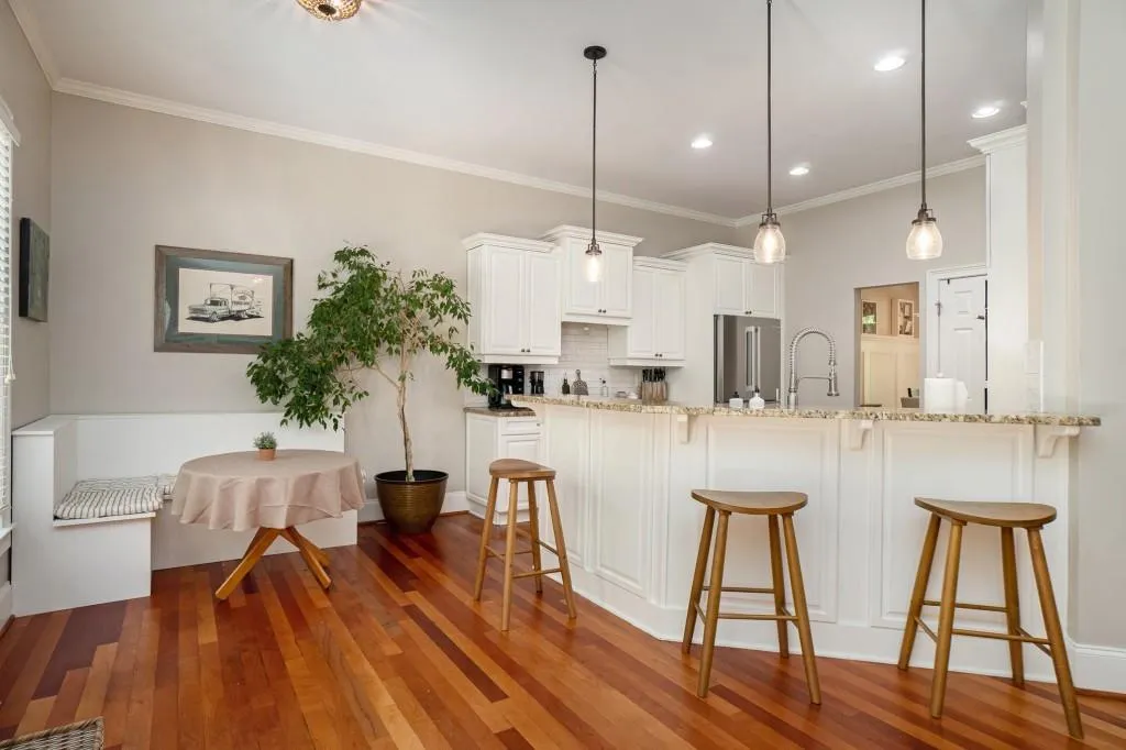 The Open Kitchen overlooks a Light-Filled Breakfast Nook and Fireside Family Room, featuring Granite Countertops, Stainless Steel Appliances, a Classic Subway Tile Backsplash, and a Central Island for extra prep space.