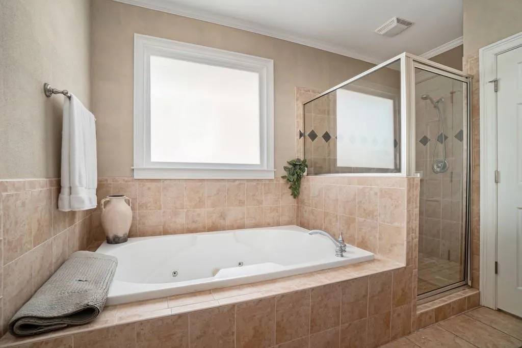 Upstairs, the Spacious Primary Suite features a Tray Ceiling, Walk-In Closet, and a Spa-Style Ensuite with Soaking Tub, Separate Shower, and Dual Vanities.