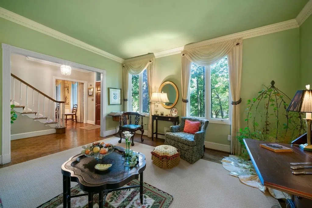 Sitting room with ornamental molding, wood finished floors, stairs, and a chandelier