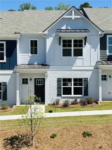 Exterior featuring painted brick, board and batten siding, horizontal siding, and a metal roof accent over the window