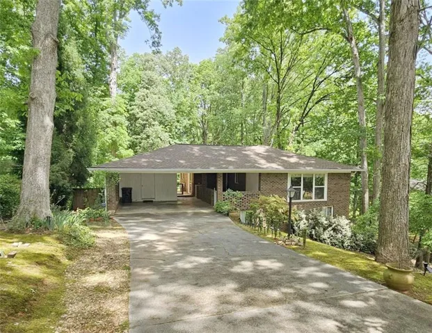 Brick ranch home with an attached 2 car carport, shop/studio, and a paved driveway