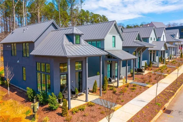 Modern inspired farmhouse featuring metal roof, a standing seam roof, a patio, and a residential view