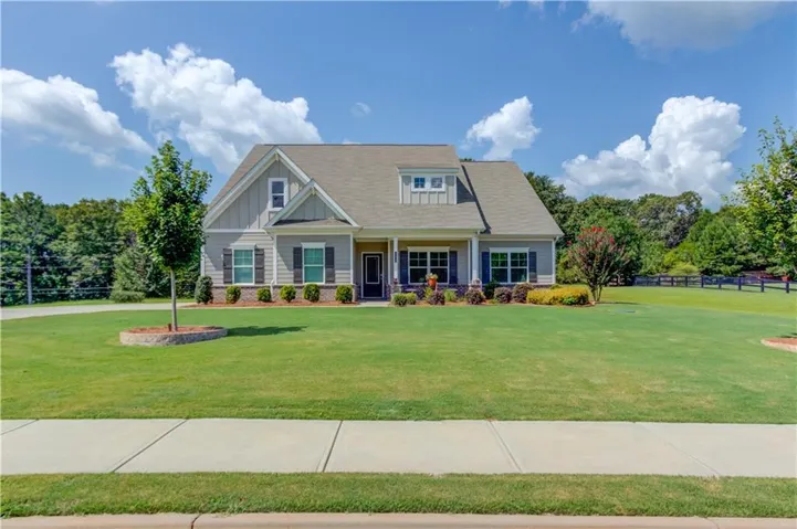 Siding exterior with dormer windows, covered front porch, and manicured lawn