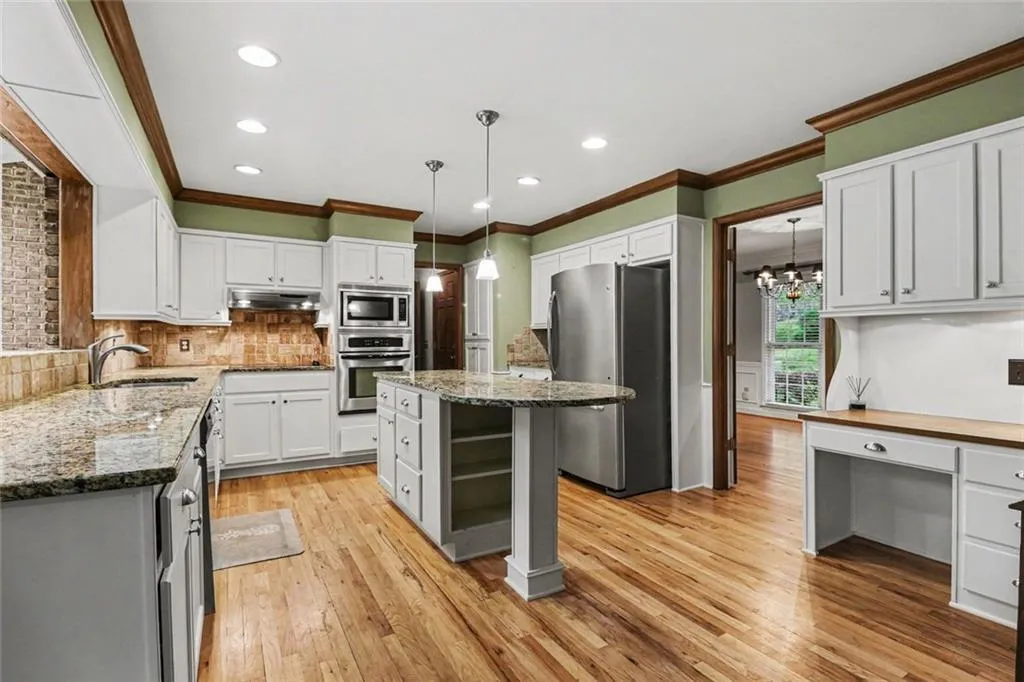 Large Kitchen with White Cabinets, Granite Countertops, Island, Built-In Desk & Stainless Steel Appliances