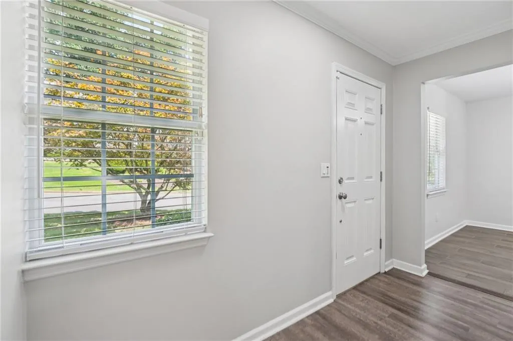 Foyer featuring dark wood-style flooring and ornamental molding