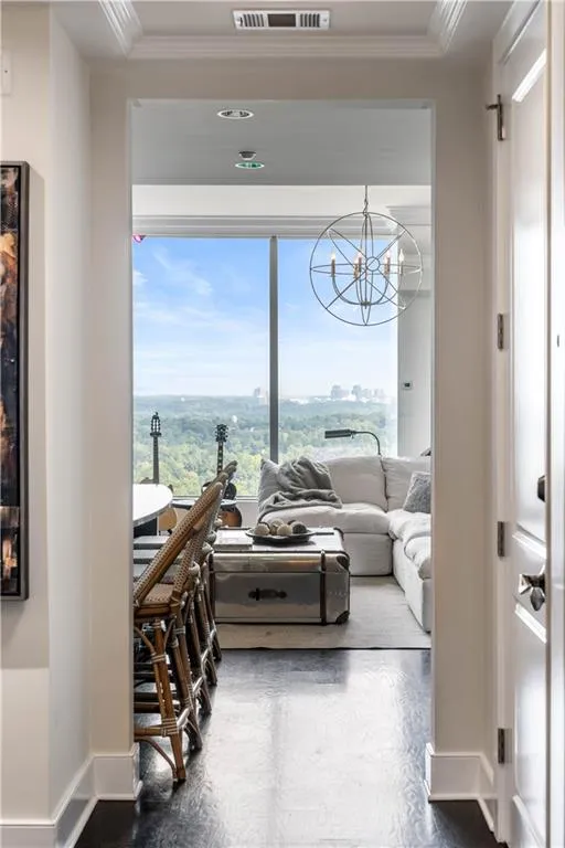 Living room with a chandelier, a view of city, and ornamental molding