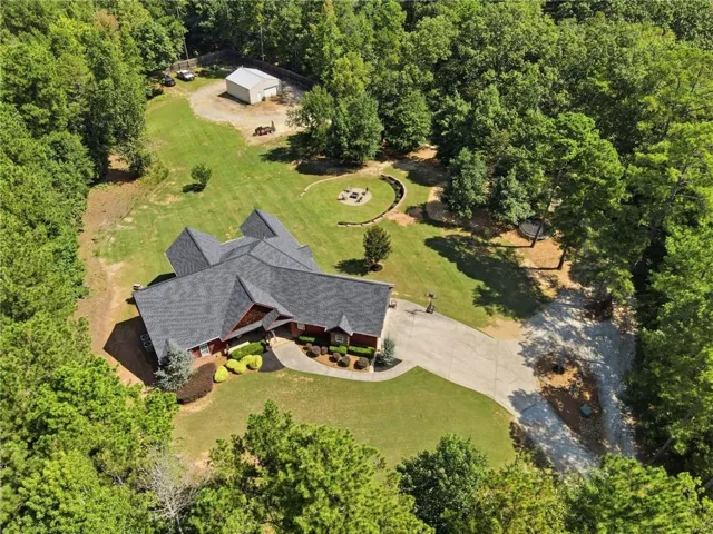 Expansive property featuring a multi-gabled roofline, concrete driveway, and a detached outbuilding