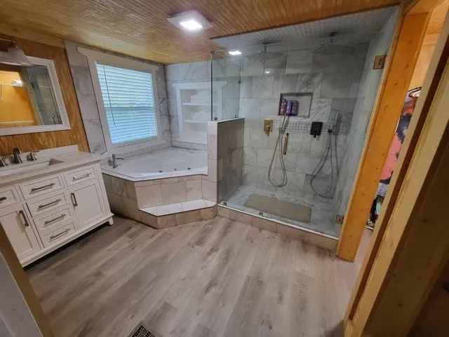 Bathroom with vanity, hardwood / wood-style floors, wooden ceiling, and independent shower and bath