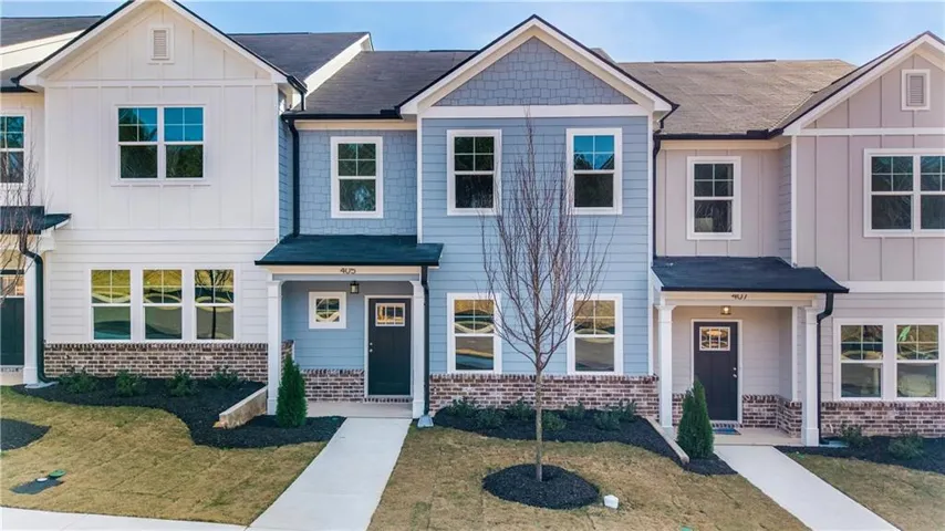 Multi-story exterior with horizontal siding, brick veneer, gabled rooflines, and covered entryways