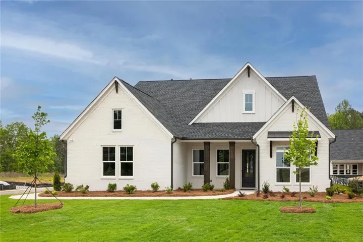 White brick exterior with dark trim and a gabled roofline