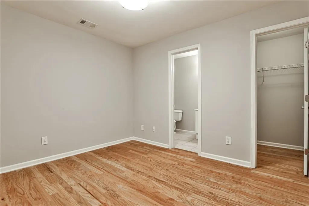 Versatile downstairs room with en-suite half bath and walk-in closet—perfect for use as a guest bedroom, home office, gym, or flex space