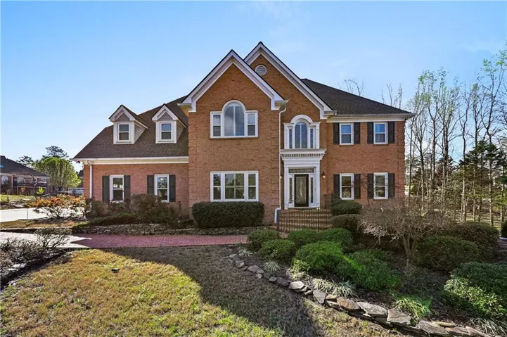 View of front facade with brick siding and a front yard