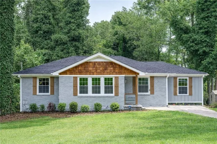Ranch-style house with a front yard, brick siding, board and batten siding, a shingled roof, and a porch
