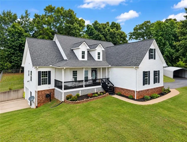 Traditional white siding exterior with a dark shingle roof