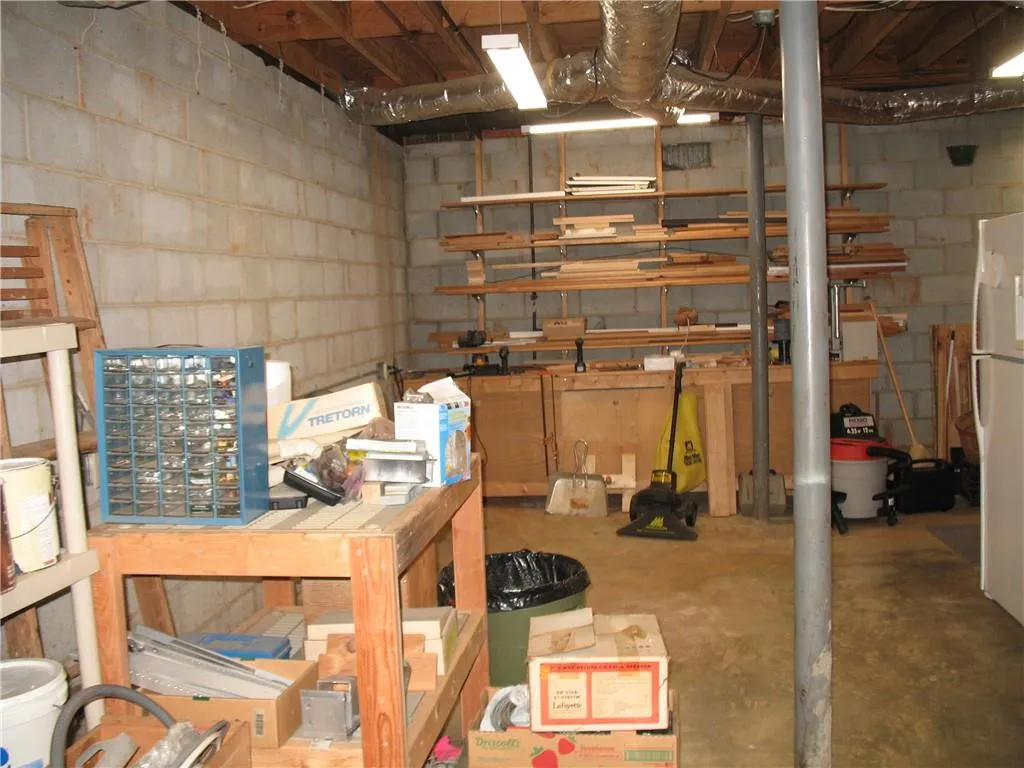Unfinished below grade area with concrete block wall - great workshop space!