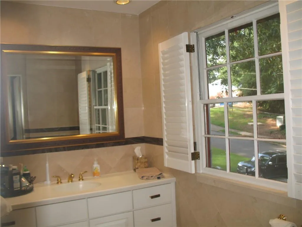 Bathroom featuring tile walls and vanity