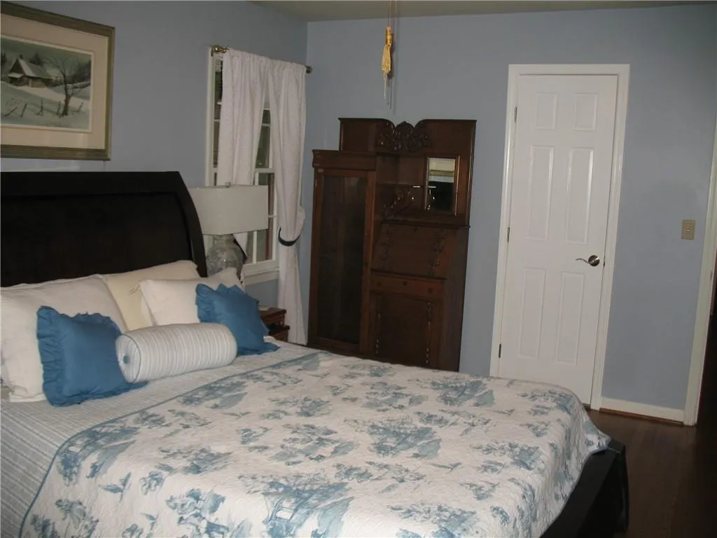 Bedroom featuring wood finished floors and baseboards