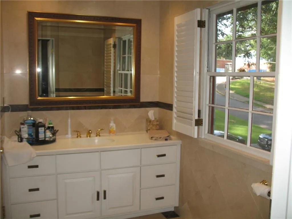 Bathroom featuring tile walls and vanity