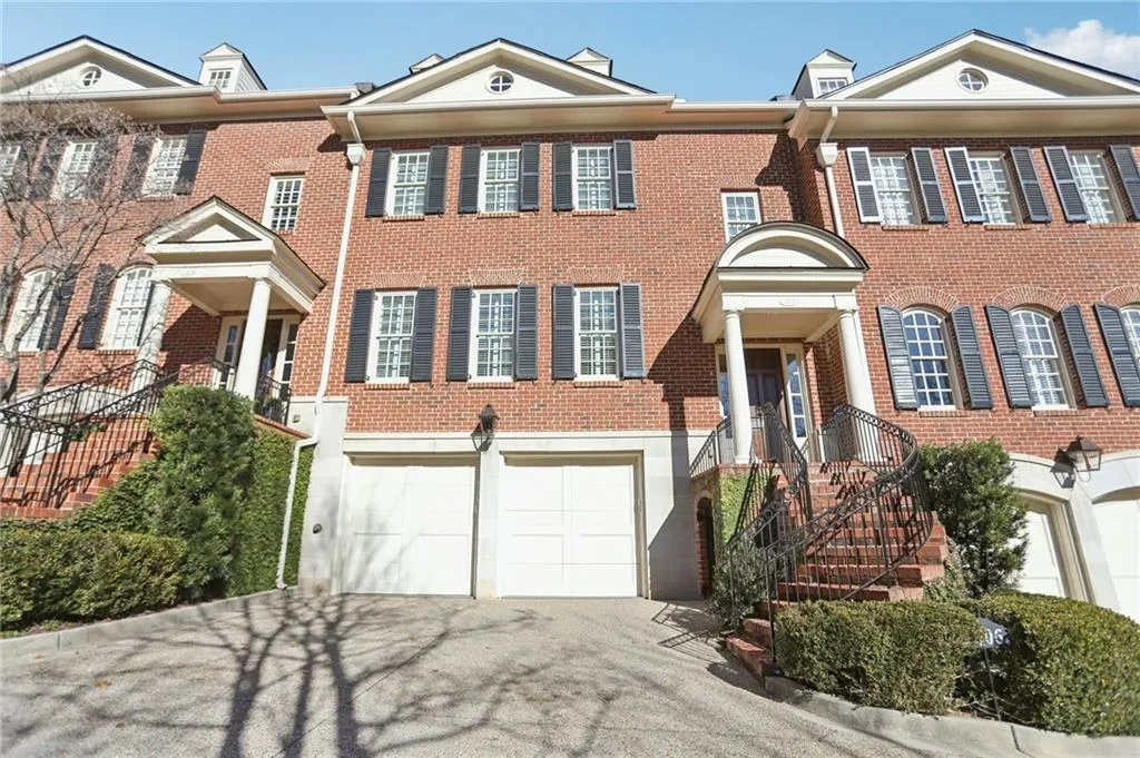 Colonial home featuring asphalt driveway, brick siding, and a garage
