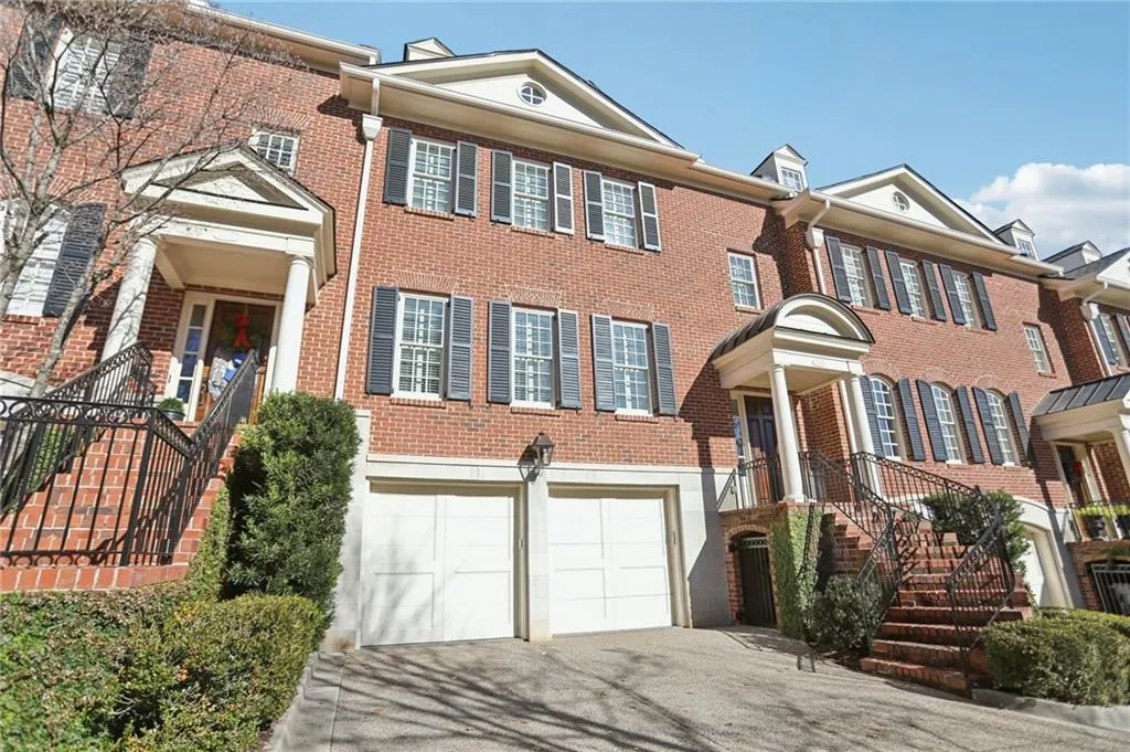 Colonial-style house featuring brick siding, driveway, and a garage