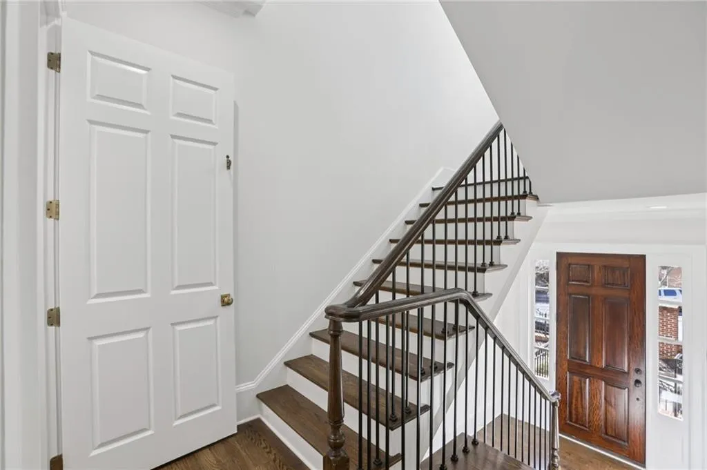 Staircase with wood finished floors and baseboards