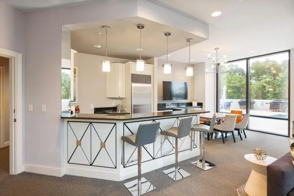 Kitchen featuring white cabinets, hanging light fixtures, built in fridge, and dark carpet