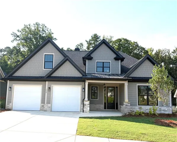 Modern craftsman exterior with gabled roof lines, gray siding, stone accents, and a two-car garage