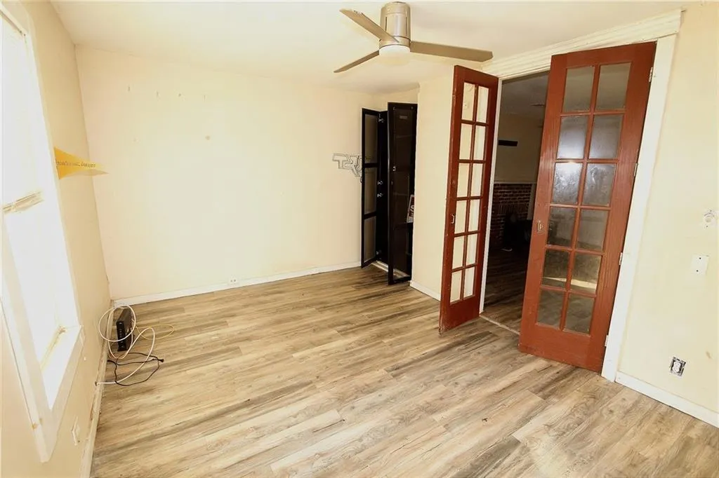 Unfurnished room featuring light wood finished floors, french doors, and a ceiling fan