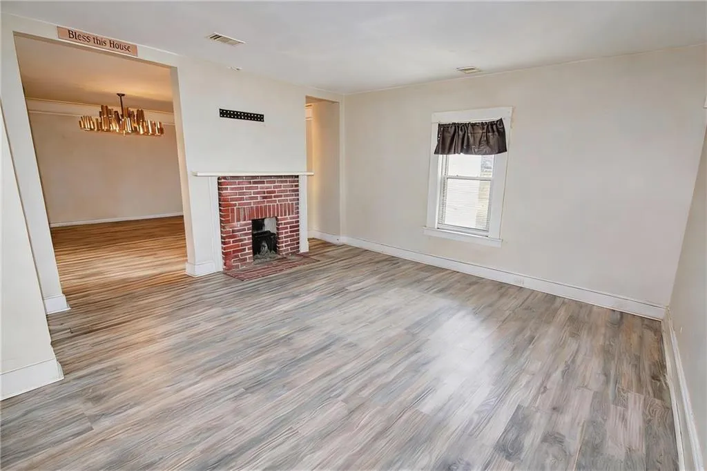 Unfurnished living room featuring wood finished floors and a fireplace