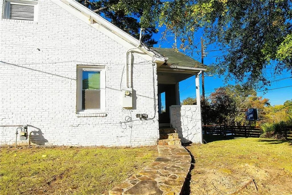 View of home's exterior with a lawn and brick siding