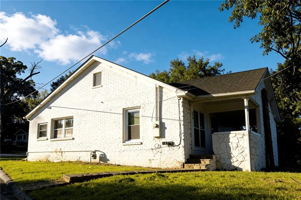 View of home's exterior featuring a yard, brick siding, entry steps, and a shingled roof