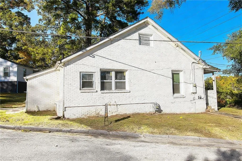 View of side of home featuring brick siding and a yard