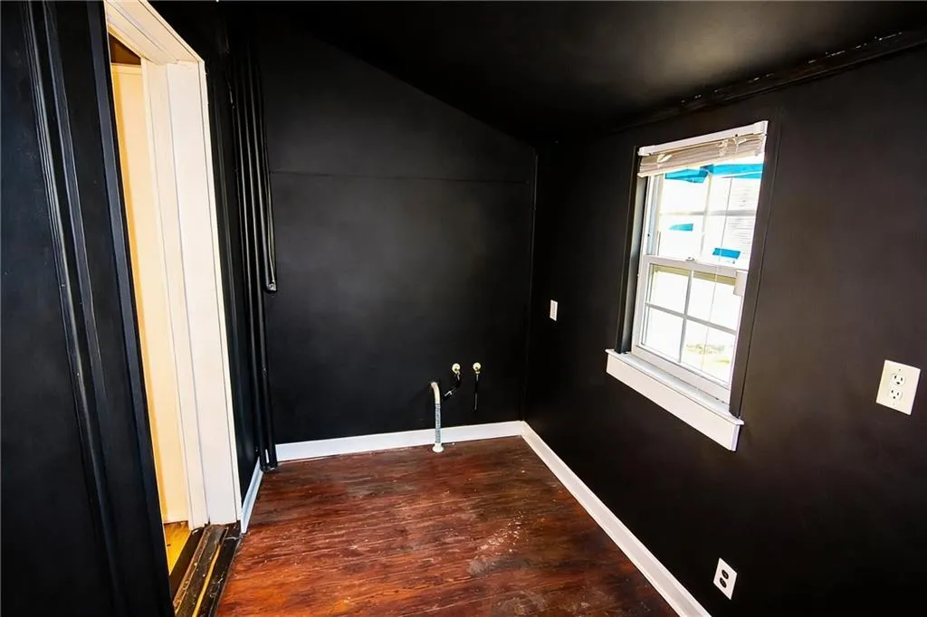 Spare room with lofted ceiling and dark wood-style flooring