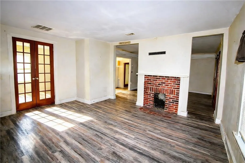 Unfurnished living room featuring french doors and dark wood finished floors