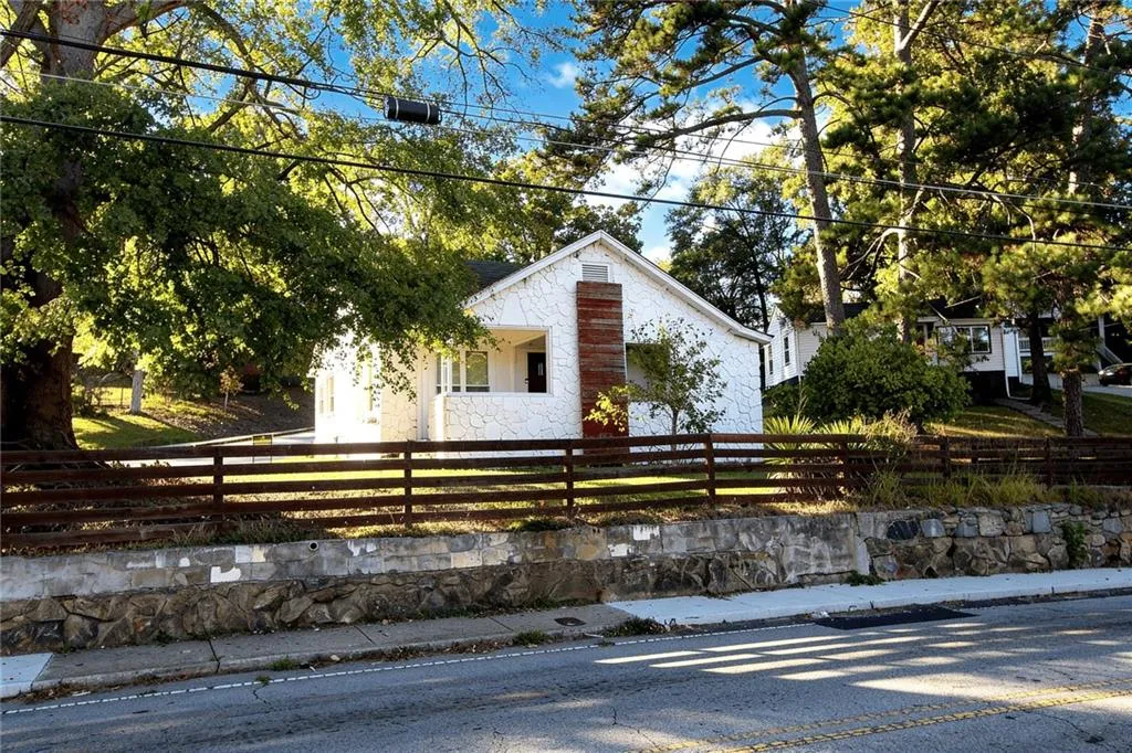 View of front of house with a fenced front yard and stone siding