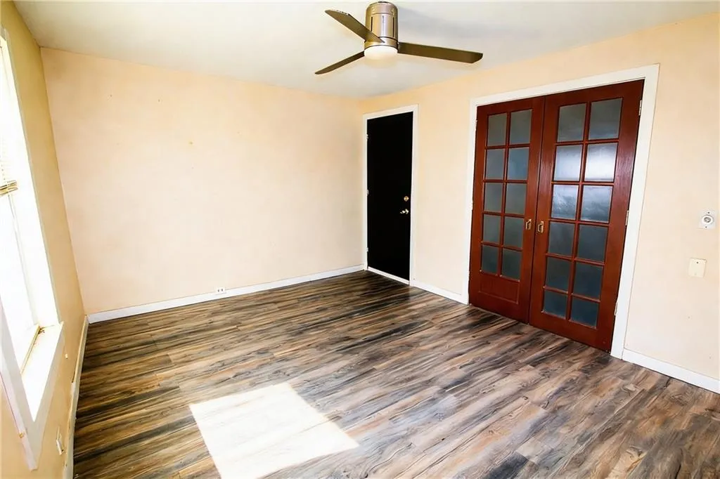Unfurnished room with french doors, dark wood-style flooring, and ceiling fan