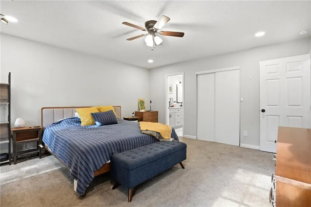 Bedroom with carpet floors, connected bathroom, recessed lighting, and ceiling fan