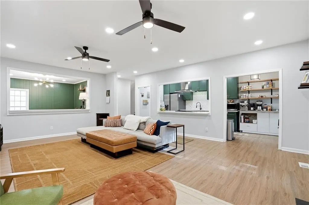 Living area featuring light wood-type flooring, a ceiling fan, and recessed lighting