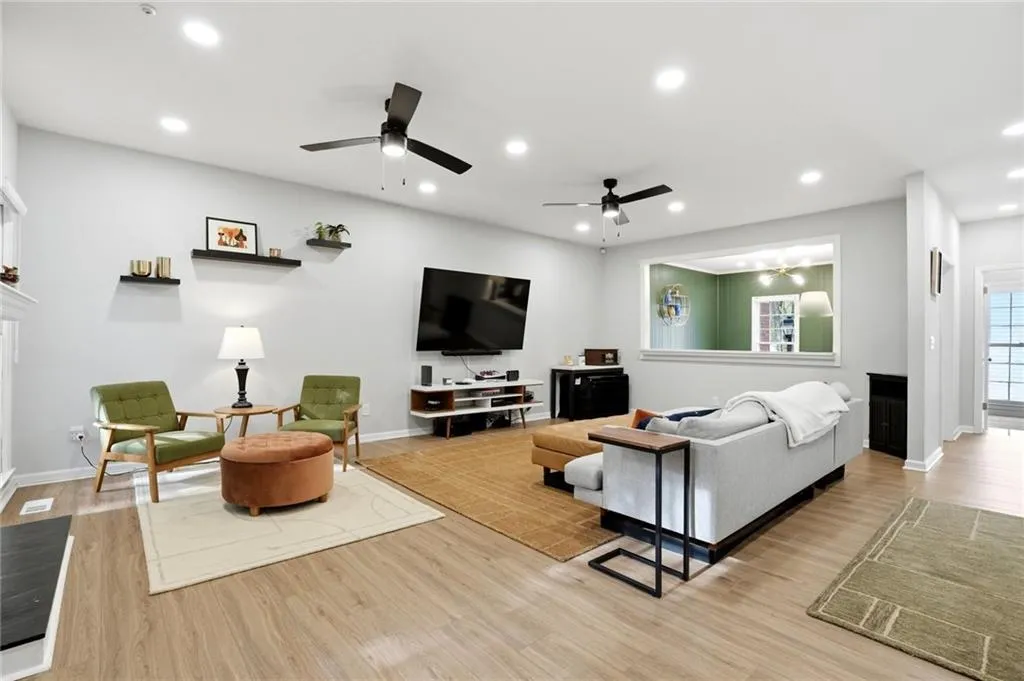 Living area featuring light wood finished floors, recessed lighting, and a ceiling fan