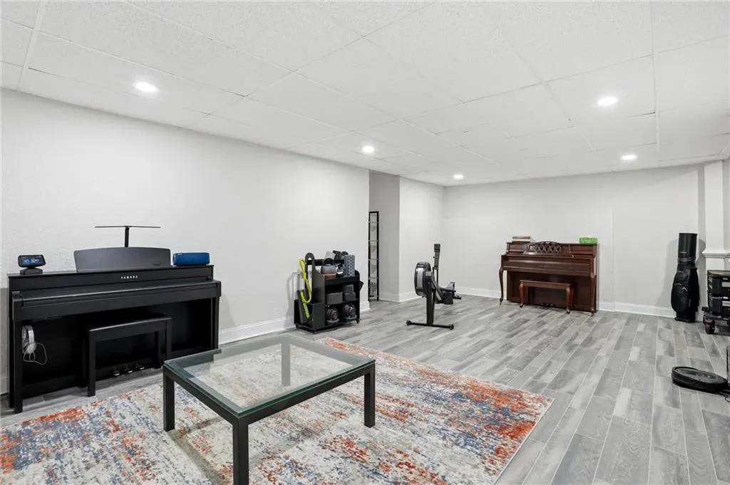 Living area with a paneled ceiling, light wood-style floors, and recessed lighting