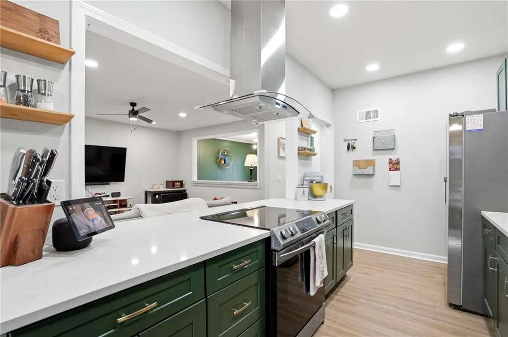 Kitchen featuring green cabinets, open shelves, open floor plan, and recessed lighting
