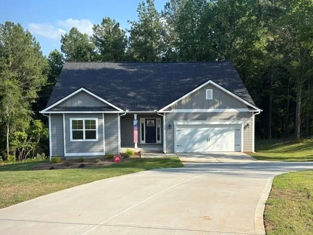 Contemporary ranch-style residence featuring grey horizontal siding and white trim accents
