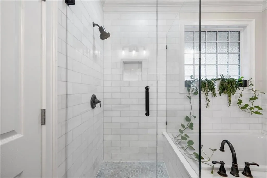 Bathroom with a shower stall, crown molding, and a garden tub