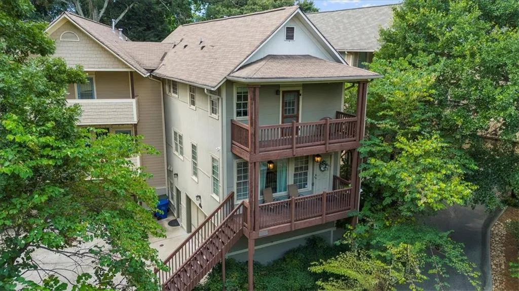 Back of house featuring a shingled roof, a balcony, and covered porch