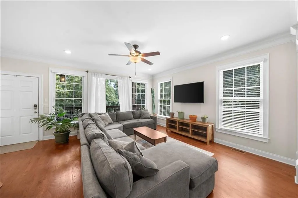Living area featuring a ceiling fan, ornamental molding, wood finished floors, and recessed lighting
