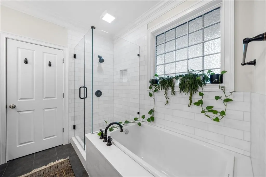 Bathroom featuring a garden tub, a shower stall, crown molding, and tile patterned flooring