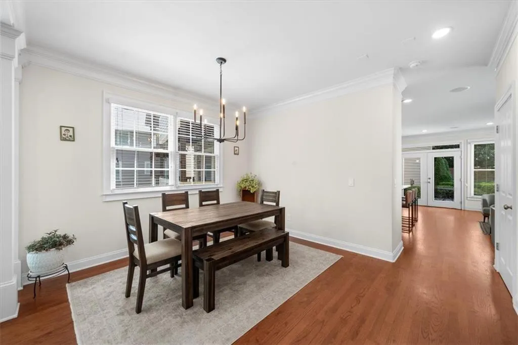 Dining room featuring a chandelier, plenty of natural light, wood finished floors, recessed lighting, and ornamental molding