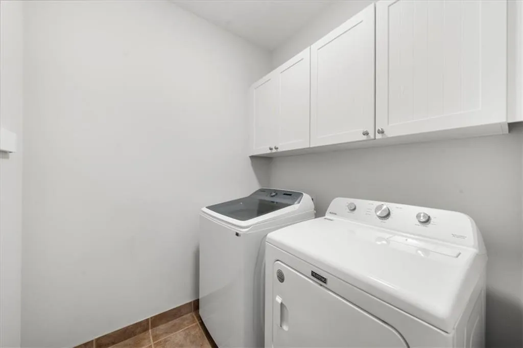 Washroom with cabinet space and washing machine and dryer